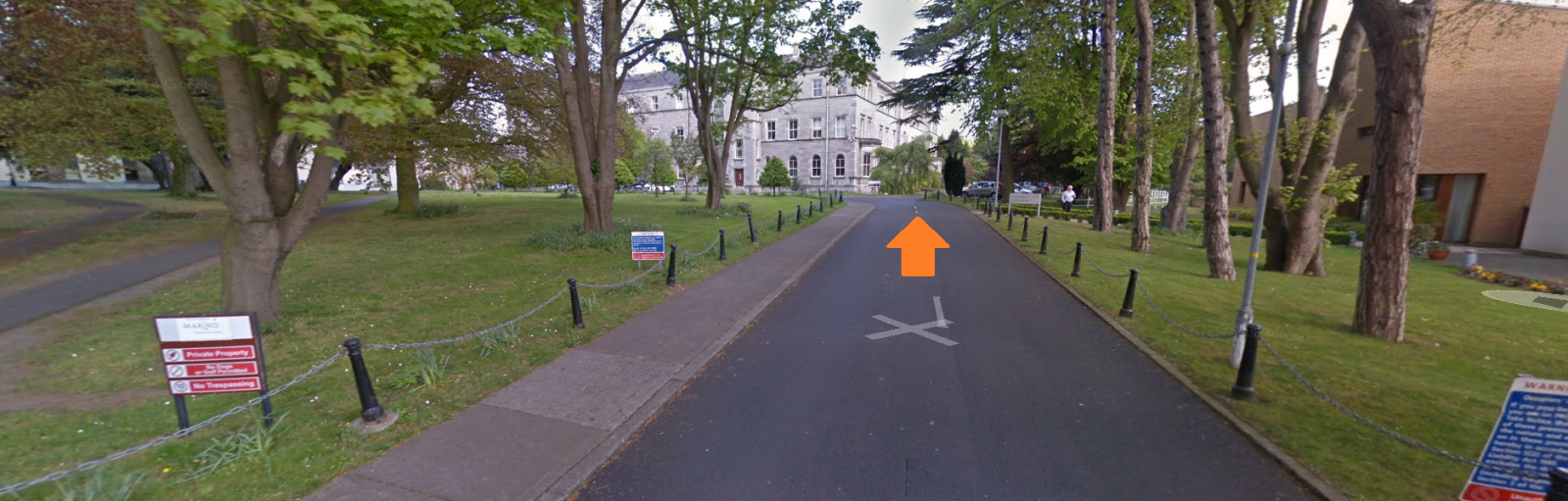 View inside Marino gate, long road up to building, orange arrow indicates to move towards building